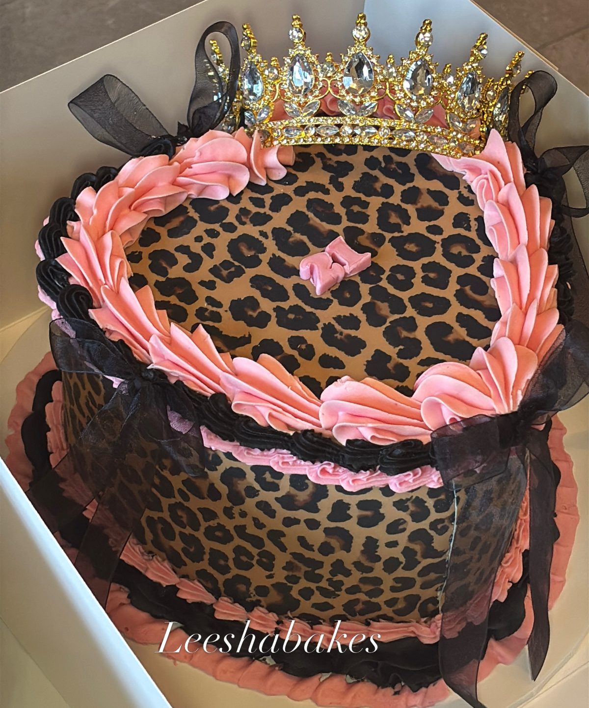 Leopard print cake with pink rosettes and crown