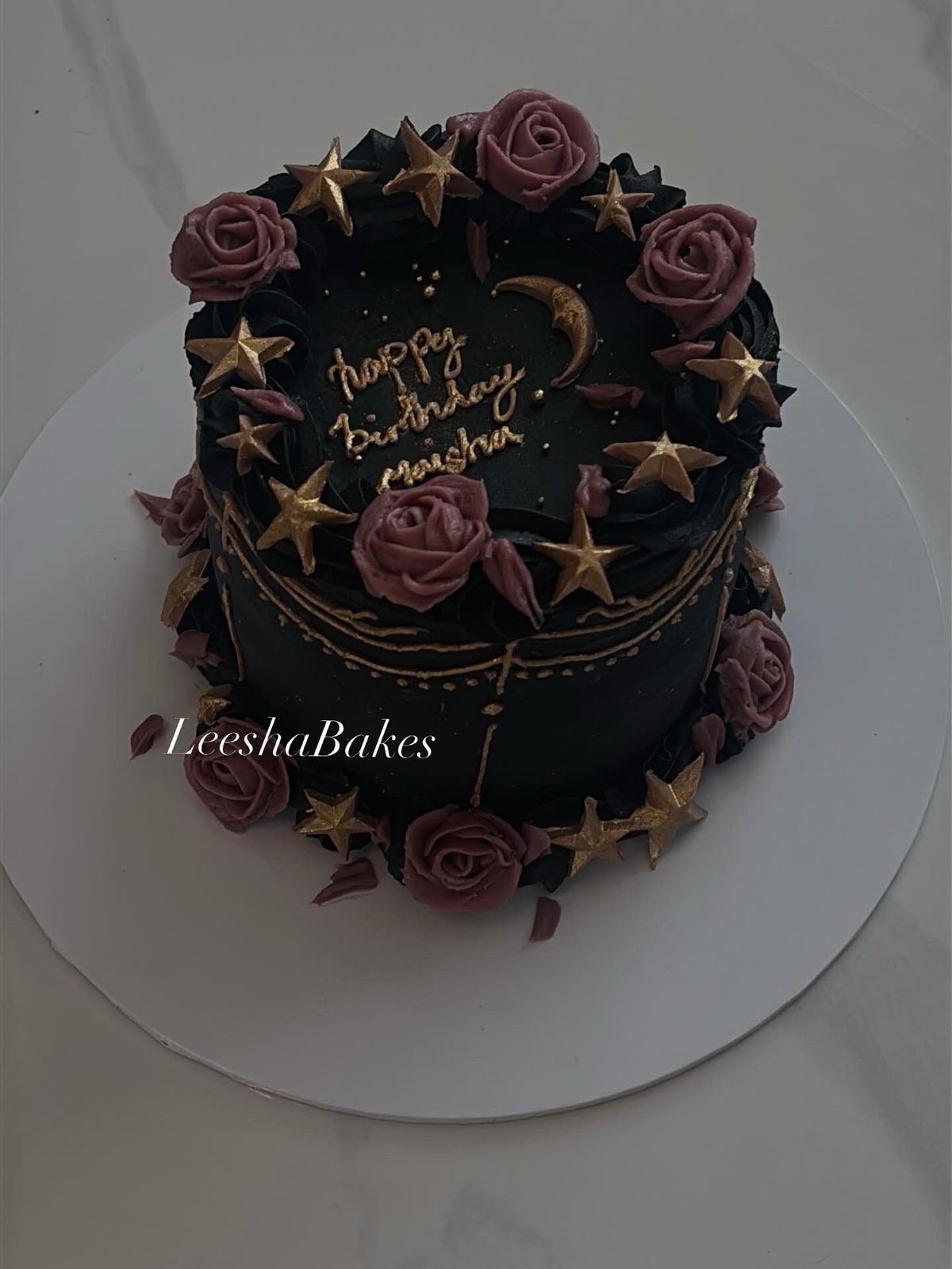 Black cake with gold stars and pink roses