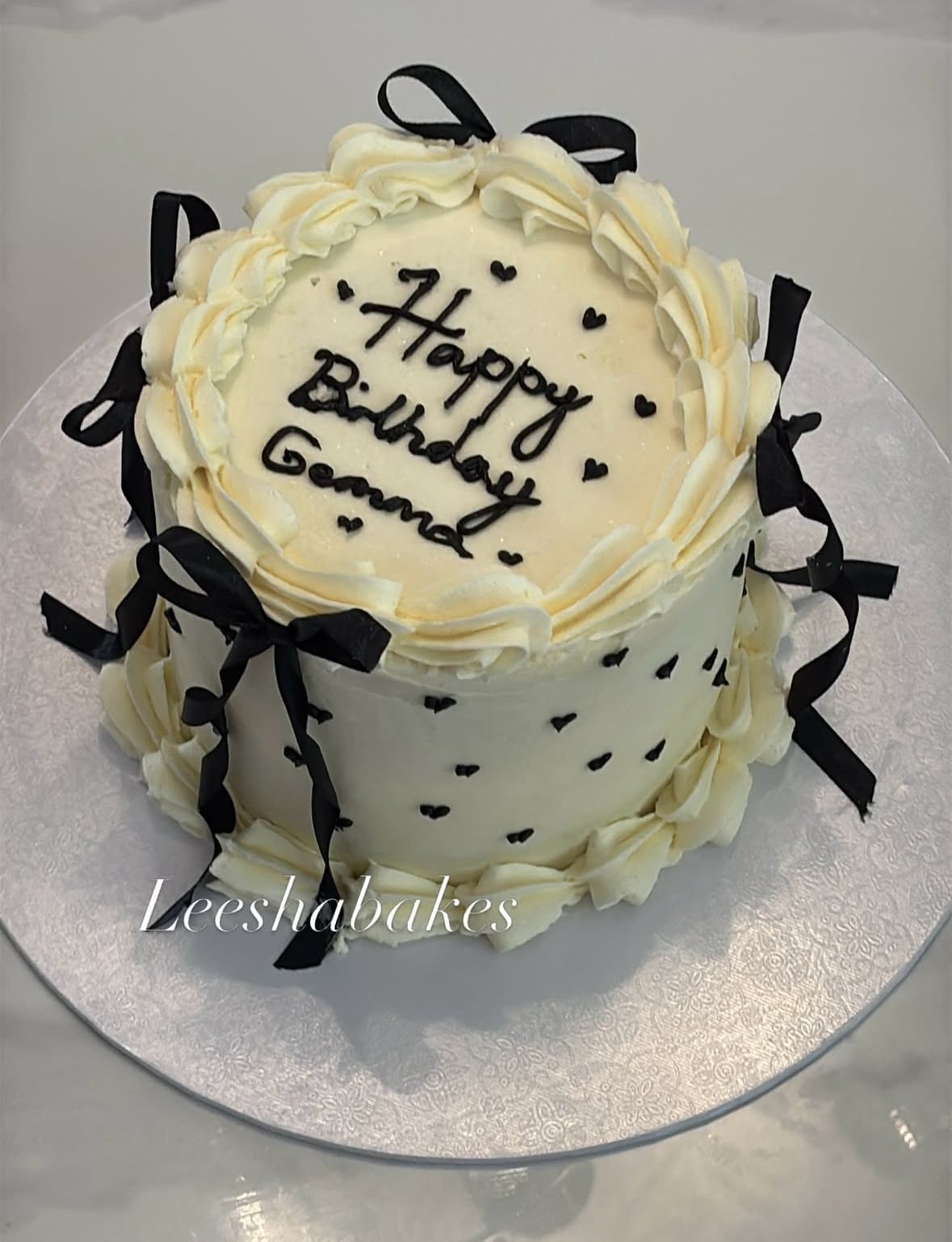 White cake with black bows for Gemma