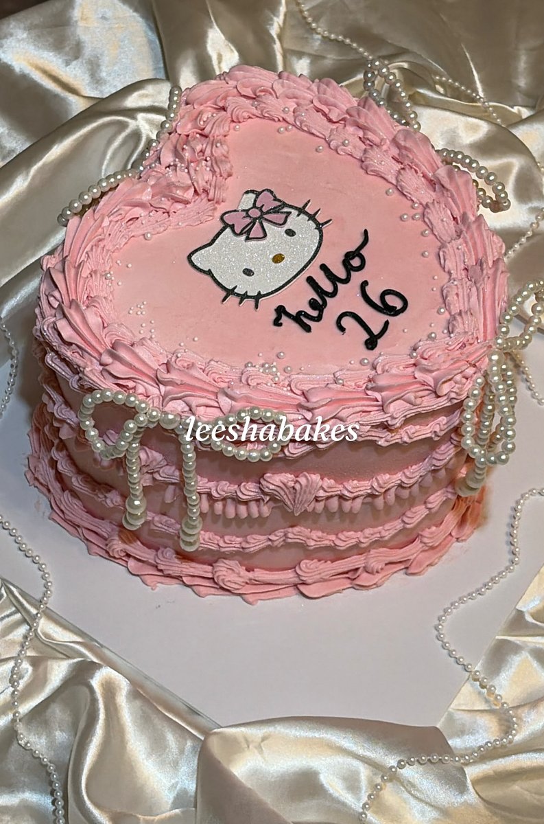 Pink vintage heart cake with pearls and a Hello Kitty topper reading 'hello 26'