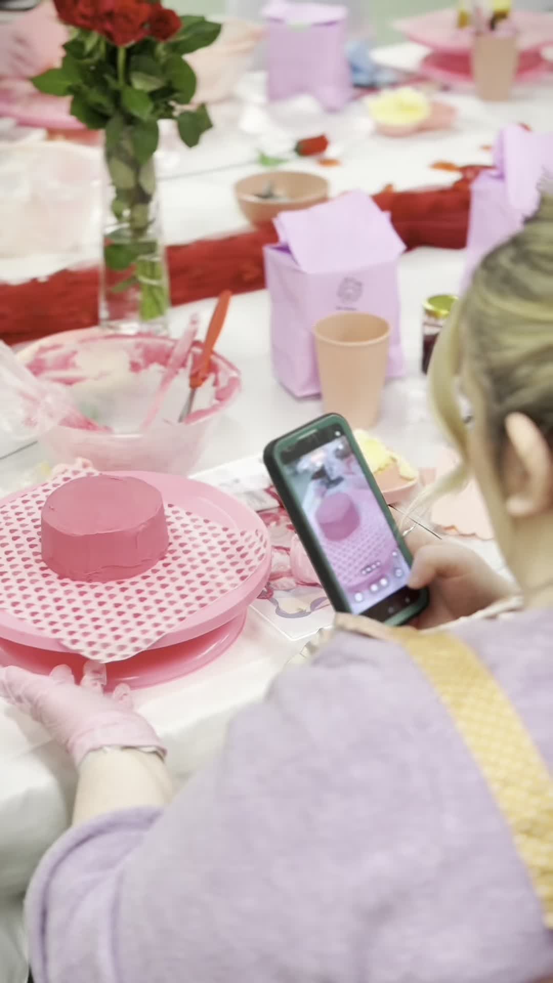 Attendee photographing her decorated pink cake