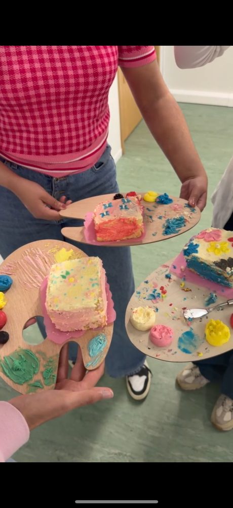 Decorated cakes held up on artist palette boards