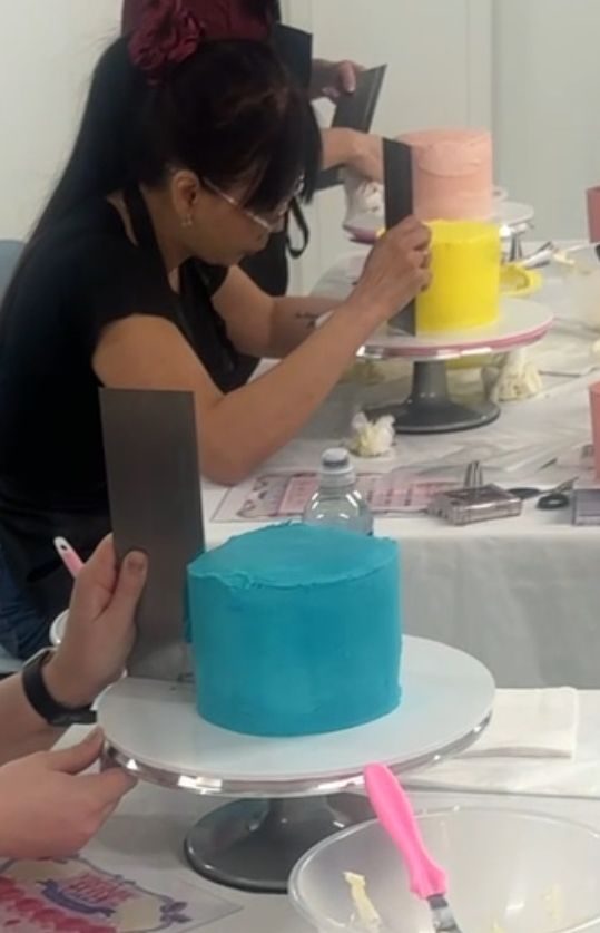 Smoothing buttercream on cakes at the class